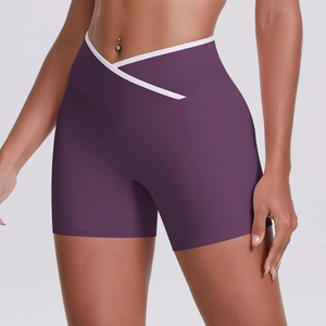 Detail of high-waisted yoga shorts featuring cross-waist design and white contrast piping