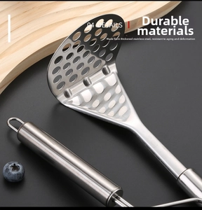 Macro view of stainless steel potato masher with dense holes and a hanging hook detail