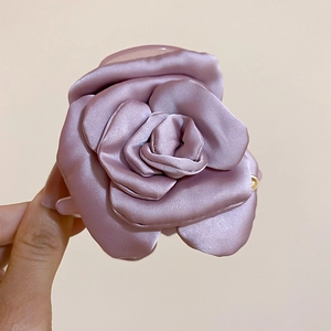 Dettaglio ravvicinato di un fermaglio per capelli a rosa in raso grigio-viola fatto a mano