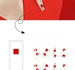 Detailed view of red and white Valentine press-on nails with heart and rhinestone accents