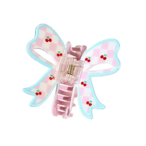 Detail of sweet bow hair claw clip featuring pink checkered pattern and cherry prints