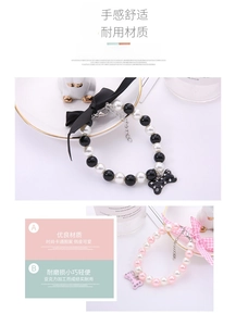Close-up of pearl pet necklaces with silk bows and rhinestone bone pendants in detail