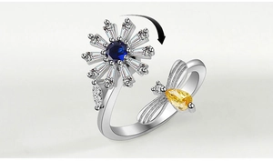Detail of spinning silver ring with zircon flower and yellow bee for anxiety relief