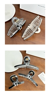 Detail view of a black and transparent bow-shaped hair claw clip with Grace lettering