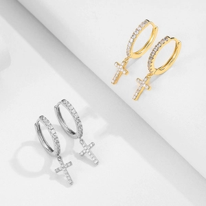 Close-up of gold and silver cross hoop earrings with sparkling micro-paved cubic zirconia