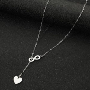 Vue détaillée du collier avec pendentif cœur infini argenté sur fond noir moderne