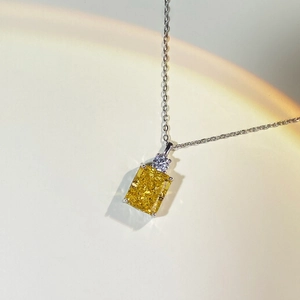 Macro shot of yellow radiant cut gemstone pendant on silver necklace chain