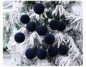 Deep blue velvet Christmas ornaments with smooth and striped patterns on snowy tree