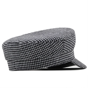 Detailed side view of houndstooth newsboy cap featuring classic black and white wool texture