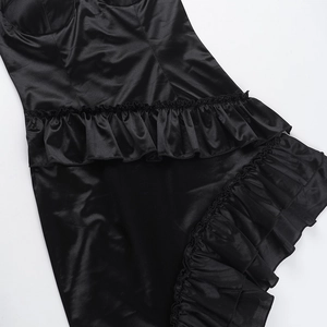 Vue détaillée de la texture satinée noire et de l'ourlet à volants de la robe