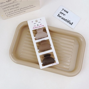 Detailed macro view of three coffee-colored matte resin mini hair claws on a card
