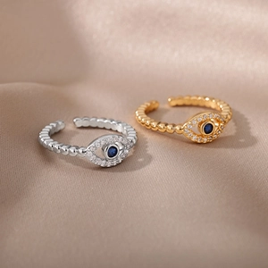 Detail of gold and silver Angel Eye open rings with blue stones on champagne silk background