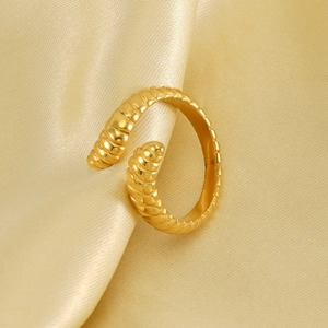 Vintage chunky croissant gold ring made of ribbed stainless steel on a satin background