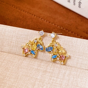 Macro shot of gold pony earrings with colorful gemstones and clear cubic zirconia stones