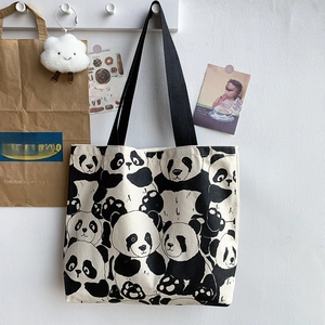 Close-up of panda print canvas tote bag featuring thick black handles and cute graphics