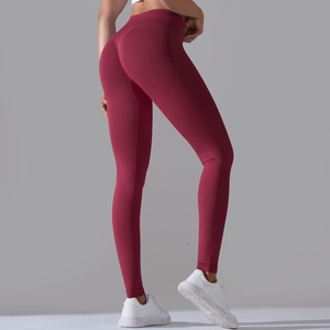 Dettaglio dei leggings da yoga rosso scuro senza cuciture con vita alta e effetto push-up