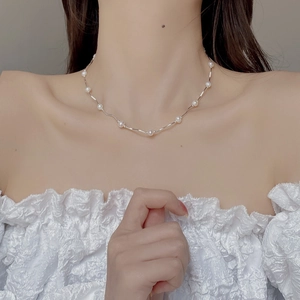 Vista modella della delicata collana in argento S925 con barra curva e perle d'acqua dolce