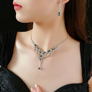 Macro detail of diamond tassel necklace and drop earrings set on elegant evening wear
