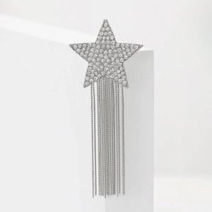 Macro detail of star brooch with sparkling rhinestones and long silver tassels