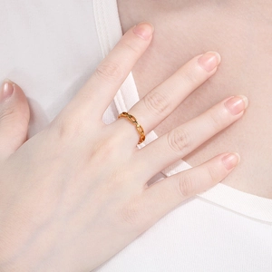 Close-up of golden hollow chain link ring showing polished oval metal texture