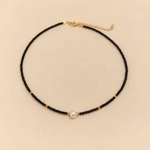 Collier minimaliste en perles facettées noires avec perle centrale et fermoir doré