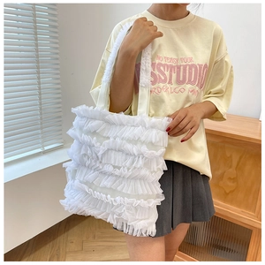 Détail du cabas blanc avec volants en dentelle superposés et mesh translucide