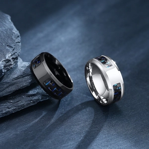 Detailed view of silver and black stainless steel rings with blue carbon fiber inlay