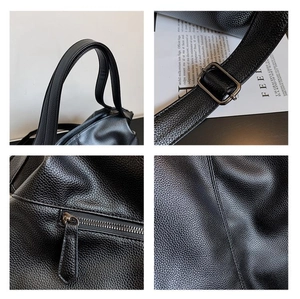 Detail view of black lychee leather texture, reinforced handles and silver metal hardware