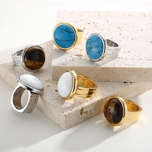 Detail of luxury titanium steel rings with assorted gemstones on stone pedestal