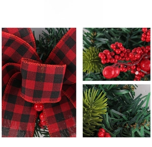 Detail of red and black buffalo plaid bow with artificial berries and pine needles