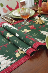 Detailed view of dark green Christmas table runner with golden reindeer jacquard texture