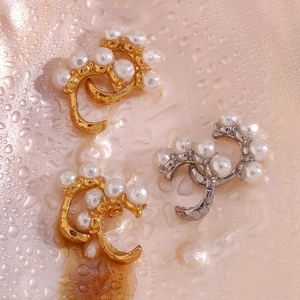 Vue à plat de boucles d'oreilles vintage en perles dorées et argentées sur surface mouillée