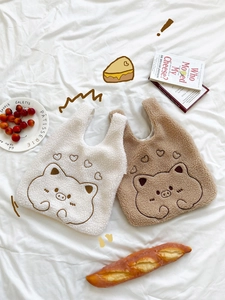 Detailed view of fluffy plush wrist bags with cute pig embroidery and heart patterns