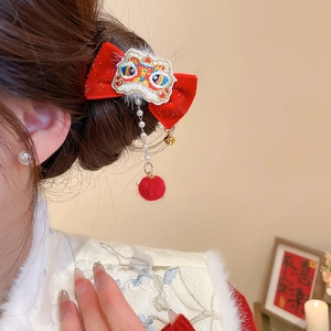 Detail of red velvet bow hair clip with lion dance embroidery and pearl tassel