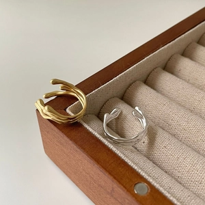 Irregular lava style open rings in gold and silver finish on a wooden jewelry box