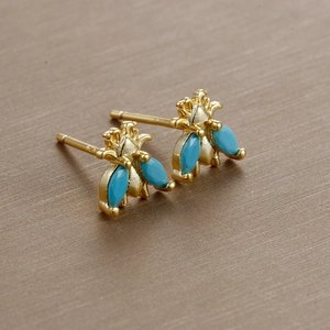 Macro shot of S925 sterling silver stamp on gold-plated bee earring with blue gemstones