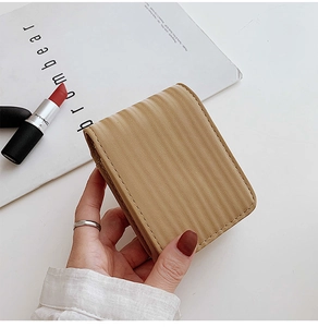 Close-up of khaki mini makeup pouch with wavy texture and convenient flip cover
