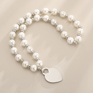 Detailansicht der Perlenkette mit weißen Perlen und silbernem Herzanhänger-Charm