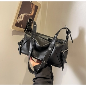 Detail of black PU leather tote bag featuring silver eyelets and metal hardware accents