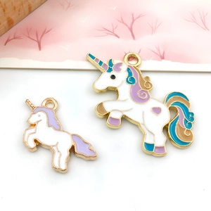 Detailed macro shot of two unicorn enamel charms with gold plating for jewelry making