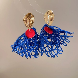 Detail of royal blue woven mesh fringe earrings with gold metal and red accents