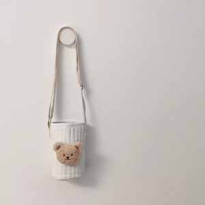 Close-up of a white quilted fabric water bottle bag with a cute brown plush bear