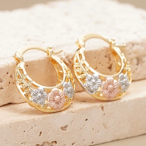 Macro-detail van driekleurige bloemen oorbellen met goud, zilver en roségoud afwerking