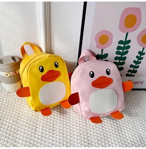 Detailed view of two cute duck-shaped toddler backpacks in bright yellow and soft pink colors