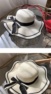Detailed weave of large brim straw sun hat with black ribbon and bow decoration