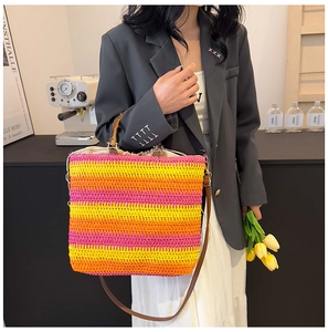 Detail of colorful striped woven beach bag with bamboo handles and brown shoulder strap