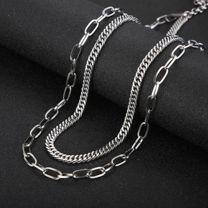 Detail of layered stainless steel chains featuring polished curb and rectangular link designs
