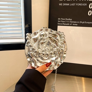 Silver 3D rose flower metal clutch bag with elegant silver chain strap held by hand
