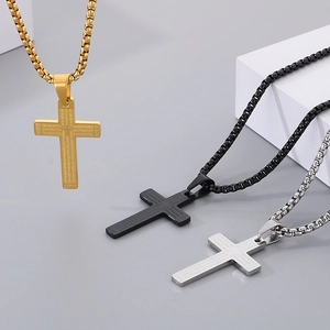 Detail of cross pendants in gold black silver with engraved Lord's Prayer text