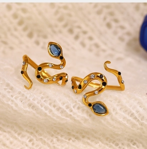 Detail of 18K gold snake ring with blue zircon teardrop and black enamel dots